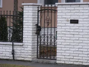 Elegáns, letisztult kovácsoltvas-jellegű kapu és kerítés.