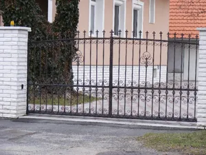 Elegáns, letisztult kovácsoltvas-jellegű kapu és kerítés.